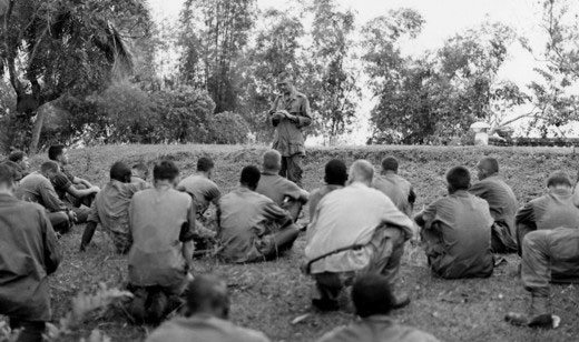 The Grunt Padre leads his men in prayer on the battlefield. Father Capodanno went into the jaws of danger to be with his men, anointing the dying and caring for the wounded.