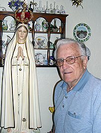 Mr. Norbert Arnold poses beside the Fatima statue of the TFP