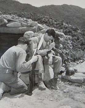 Chaplain Harold O. Prudell hears a soldier’s confession on the front lines of Korea, June, 1951