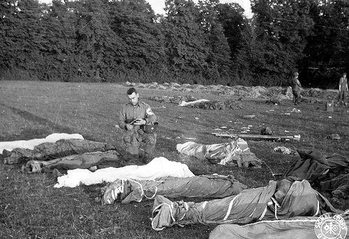 Fr. Francis L. Sampson giving Last Rites to paratroopers killed in action during the D-Day invasion of Normandy.