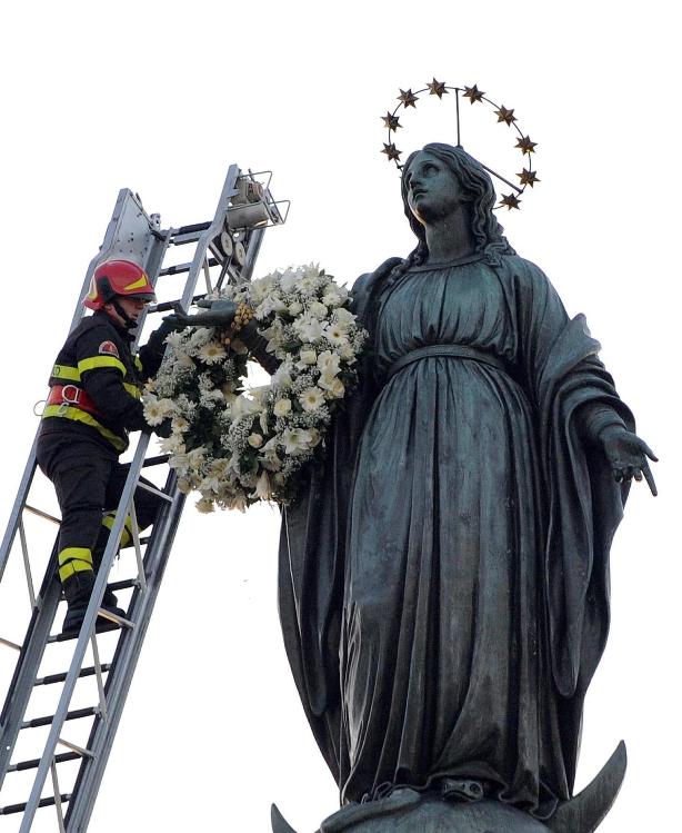 Firefighter places a wreath on the arm of Our Lady of the Immaculate Conception on her feast day in Rome, Italy
